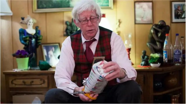 Un hombre abre un regalo