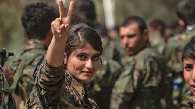 জয়সূচক চিহ্ন দেখাচ্ছে এসডিএফের একজন নারী সৈনিক