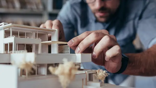 hombre montando una maqueta.