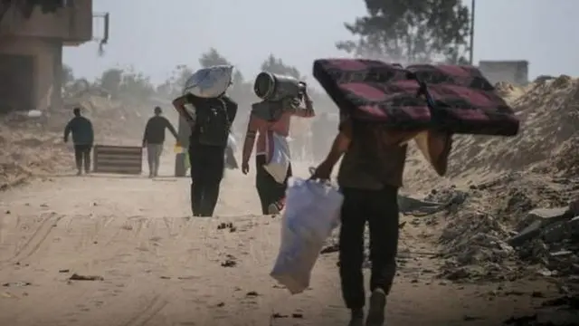 Ўзлари учун зарур буюмларни елкасида кўтариб кетаётган эркаклар