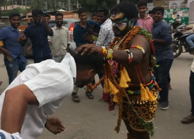 పోతురాజు వేషంలో ఓ వ్యక్తిని ఆశీర్వదిస్తున్న శివ