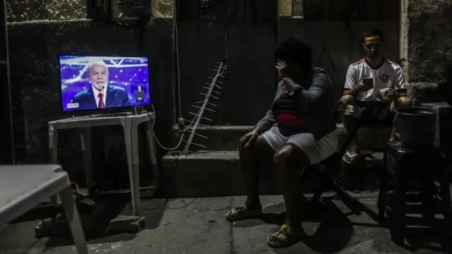 eleitores assistem Lula na TV durante debate