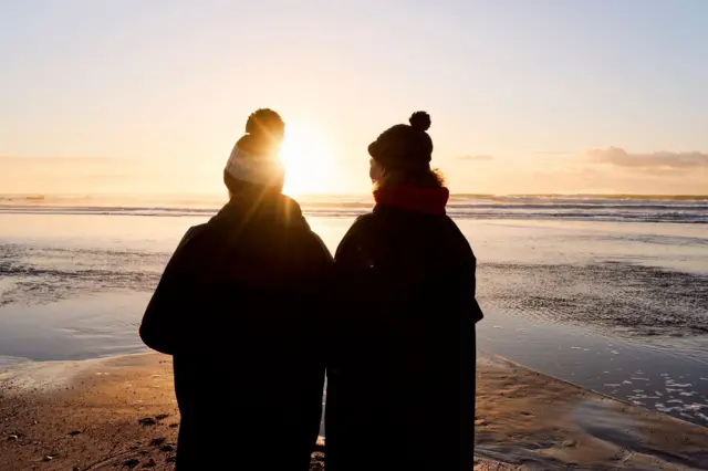 Deniz kenarında duran bir kadın ve erkek