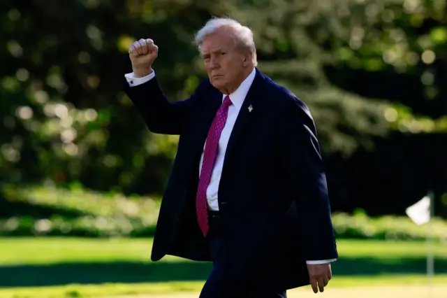 Дональд Трамп йде галявиною і піднімає вгору кулак