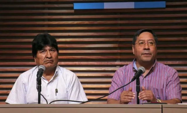 Evo Morales y Luis Arce sentados lado a lado en una conferencia de prensa