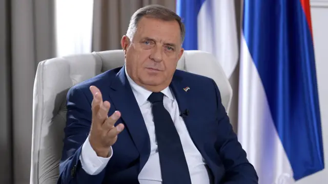 Политик в синем пиджаке смотрит в камеру