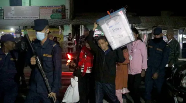 मत पेटिका बोक्दै सुरक्षाकर्मी र अधिकारीहरू