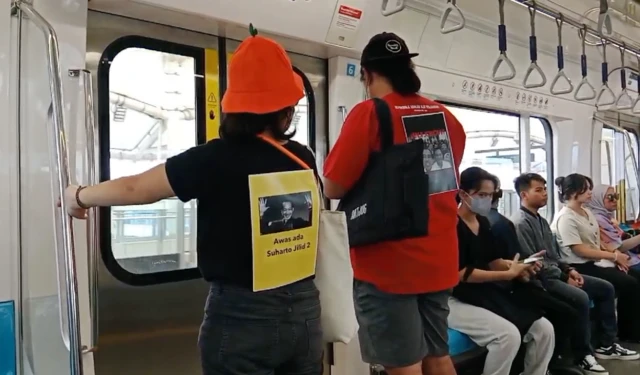 Sejumlah kelompok sipil menyematkan poster di punggung mereka, mengkritisi pemerintahan Jokowi dan rezim baru dari Prabowo-Gibran di kereta MRT pada Minggu (20/10)