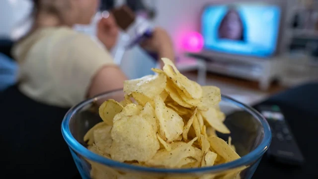 Tijela com batata fritatrancaonfrente a TV