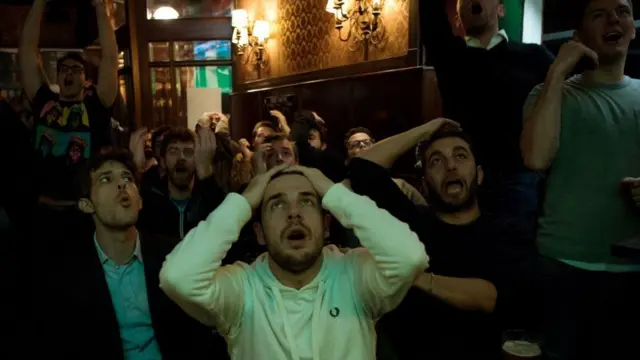 Público gritando en un bar