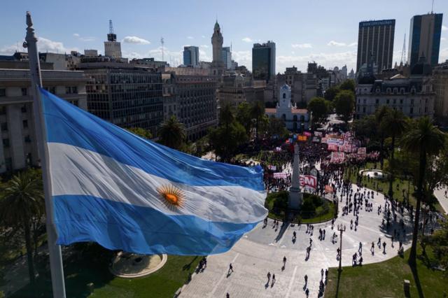 Foto tirada do alto mostra bandeira argentina e manifestantes na rua