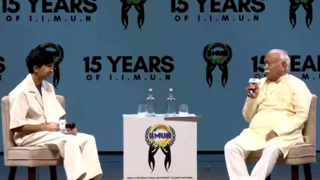 मोहन भागवत और एक प्रेज़ेंटर कुर्सी पर बैठे हैं और दोनों के हाथों में माइक है