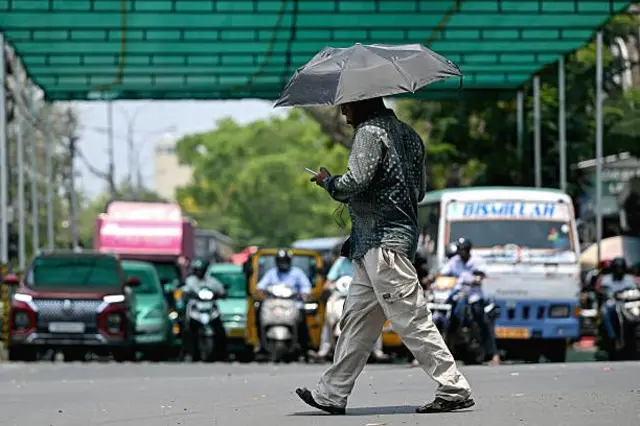 ਗਰਮੀ ਤੋਂ ਬਚਣ ਲਈ ਛਤਰੀ ਦਾ ਇਸਤੇਮਾਲ ਕਰਦਾ ਹੋਇਆ ਸ਼ਖਸ