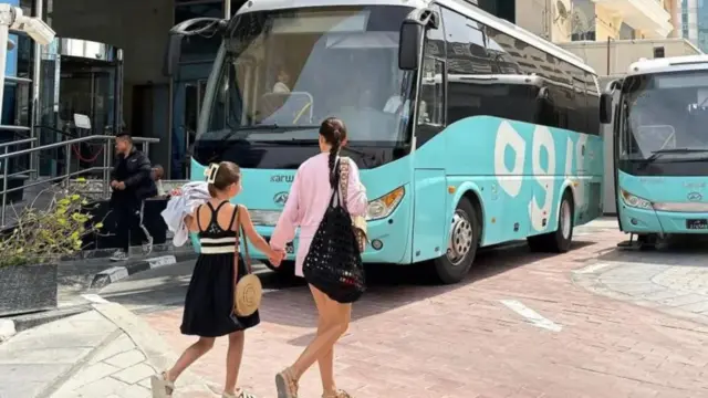 Two pipo dey waka for di front of buses