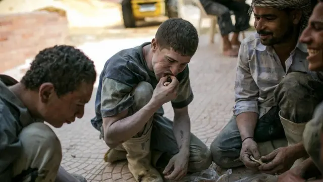 عمّال بناء يتناولون الطعام على الأرض