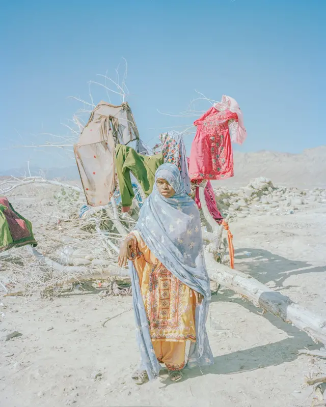 Young girl drying clothes on dead tree