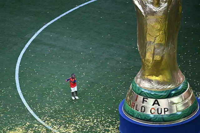 El pequeño hermano de Lamine Yamal, Keyne, junto a un decorado del trofeo.