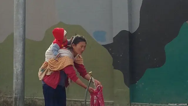 बाळाला पाठीशी बांधून काम करणारी अरुणाचली महिला.