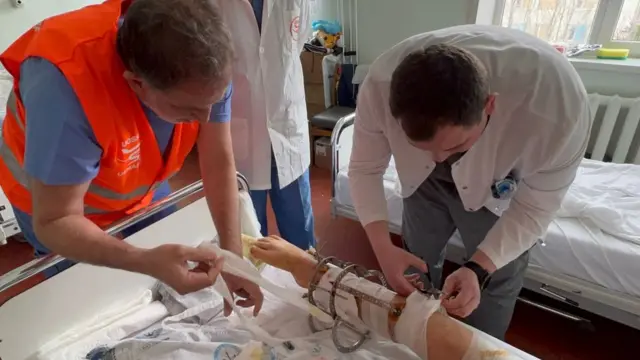 Dr Monzer Yazji and another doctor dressing a injured leg
