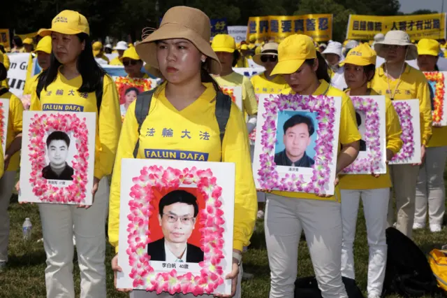 Falun Gong protesters hold images of members they say were killed by the Chinese state