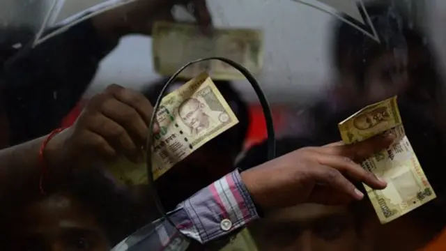 Manos con billetes en el mostrador de un banco