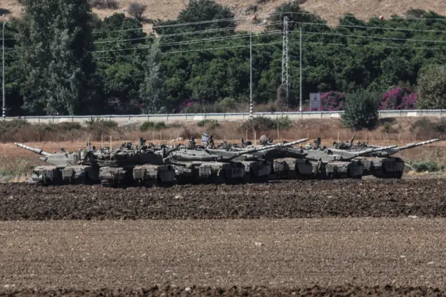 A group of about ten battle tanks parked in a circle