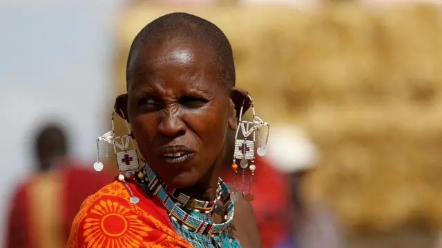 She is at a temporary animal feed market in the Ilbisil settlement of Kajiado, Kenya, where cows have become emaciated.