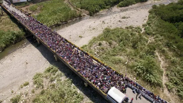 Толпа венесуэльцев на мосту в Колумбию