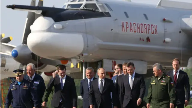 Vladimir Putin e outras autoridades na frentede apostasum Tupolev Tu-95 BEAR