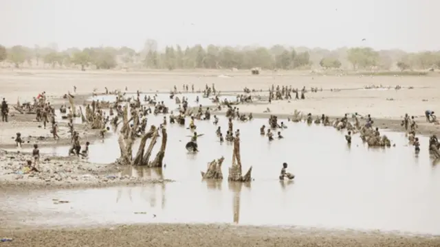 Des enfants pêchant dans un lit de rivière asséché au Burkina Faso