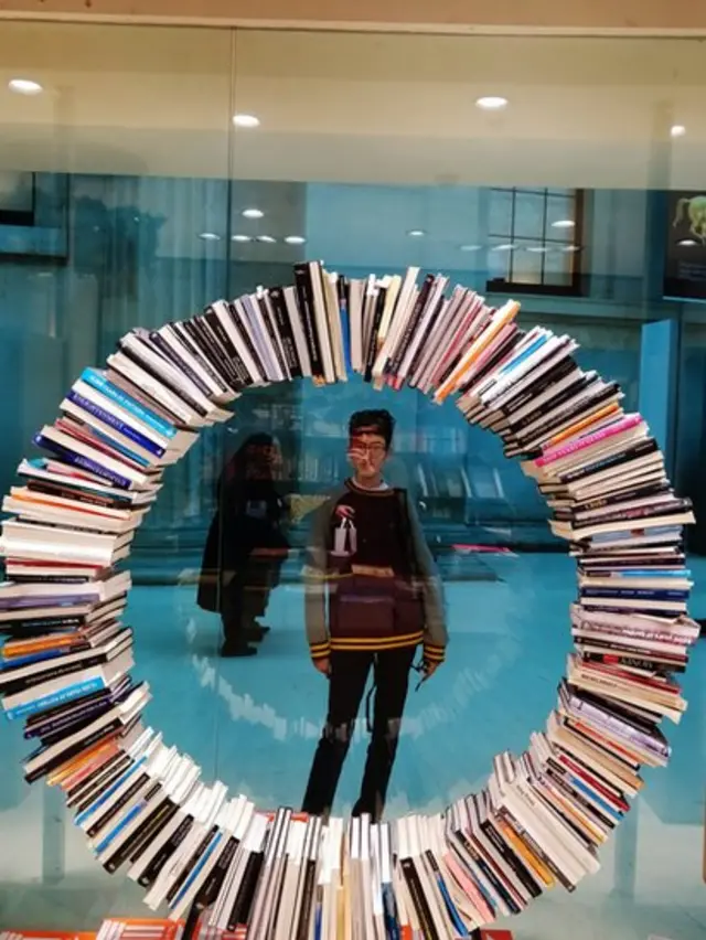 Libros ante una ventana.