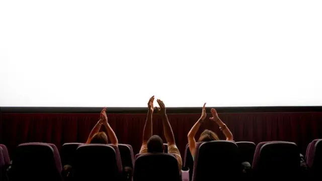 personas aplaudiendo en el cine
