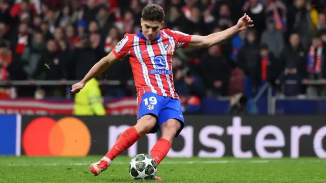 Julian Alvarez slips as he takes his penalty