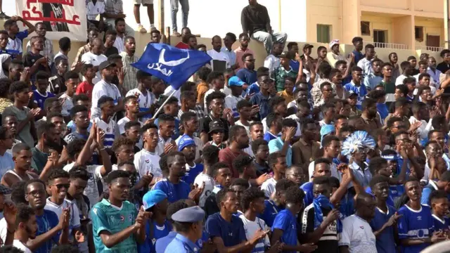 جانب من مشجعي فريق الهلال يرتدي معظمهم ملابس باللونين الأزرق والأبيض