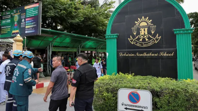 緊急救援人員站在泰國曼谷郊外暖武里府挽粿縣（Bang Kruai）的帖詩琳暖武里學校校園外（7/8/2026）