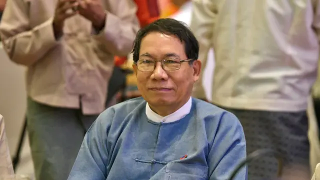 တိုက်ပုံဝတ်၊မျက်မှန်တပ်ထားတဲ့ဒေါက်တာအေးမောင်