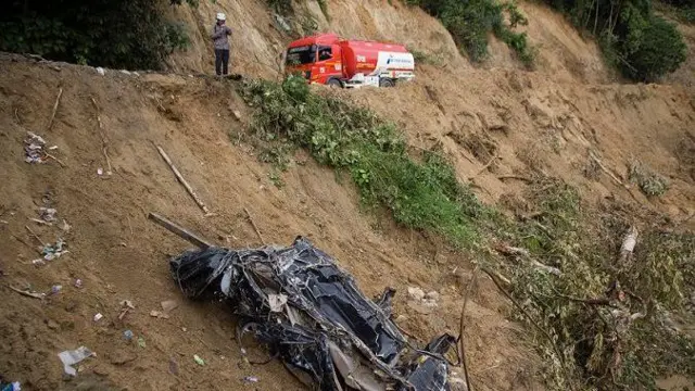 Warga mengamati kendaraan yang hancur terseret arus sungai Batang Tarusan pasca banjir bandang di Kecamatan Koto Sebelas Tarusan, Pesisir Selatan, Sumatera Barat, Senin (11/3/2024).