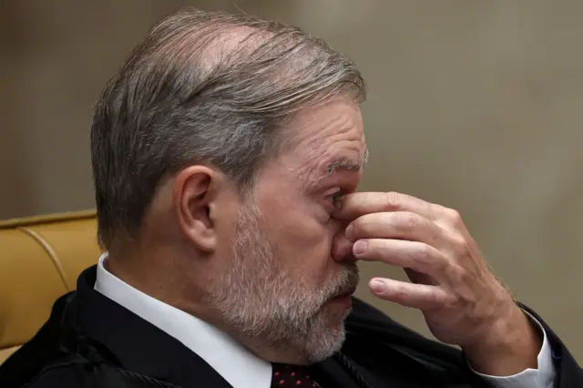 Toffoli com uma mão no rosto, coçando os olhos