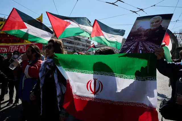 एक मार्च को एथेन्स में ईरान के सुप्रीम लीडर ख़ामेनेई की मौत के बाद प्रदर्शनकारियों ने रिवोल्यूशनरी गार्ड के कमांडर क़सेम सुलेमानी की तस्वीर लिए विरोध जताया