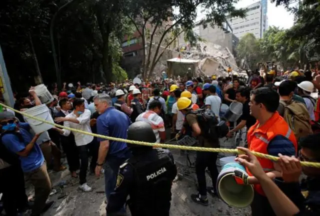 People wey dey stay for Mexico city use bucket to help remove rubble from one collapsed building.