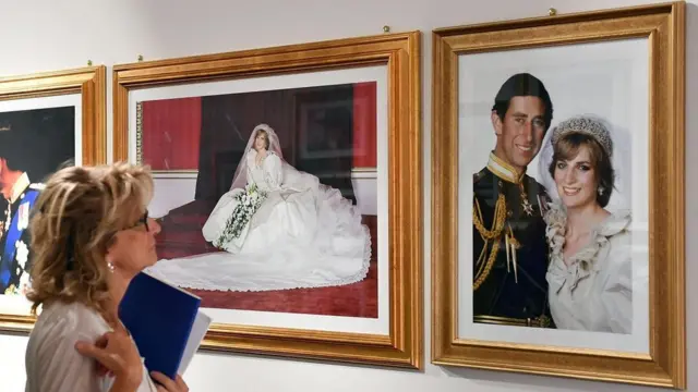 Mujer mira imágenes del casamiento de Carlos y Diana.