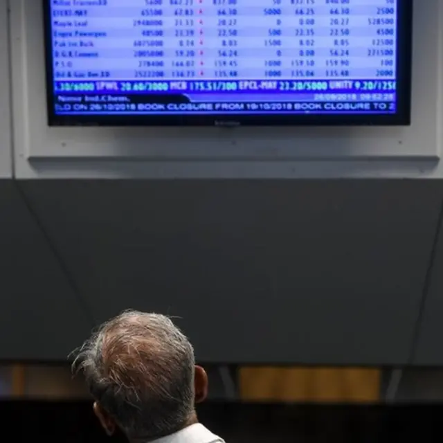 पाकिस्तानी स्टॉक मार्केट को देखता एक निवेशक