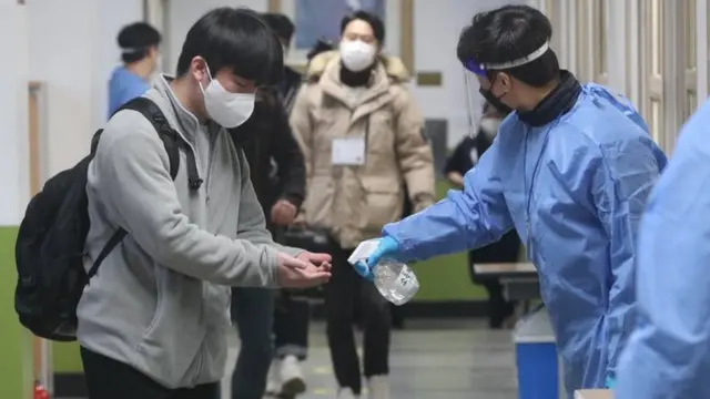 충북 청주고등학교에서 수험생들이 시험장으로 들어서며 손 소독을 하고 있다