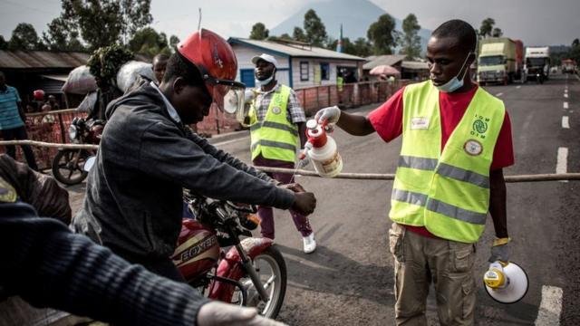 Um taxista lava as mãos em uma estação de detecção de ebola na República Democrática do Congo