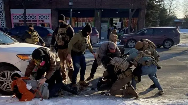 Группа агентов иммиграционной службы над человеком на земле