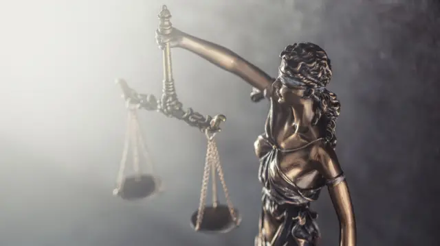 হাতে দাঁড়িপাল্লা নিয়ে চোখ বাঁধা অবস্থায় দাঁড়িয়ে থাকা থেমিসের ভাস্কর্য