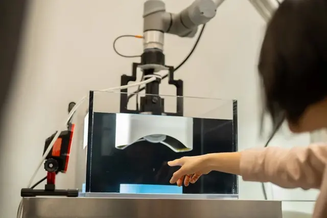 Cientistas apontando para um aparelho