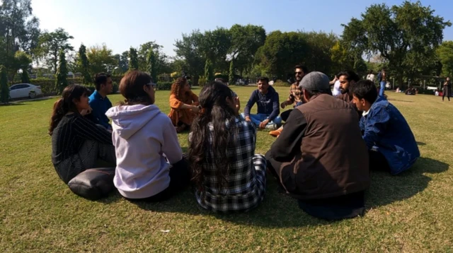 들판에 모여 앉은 파키스탄 학생들