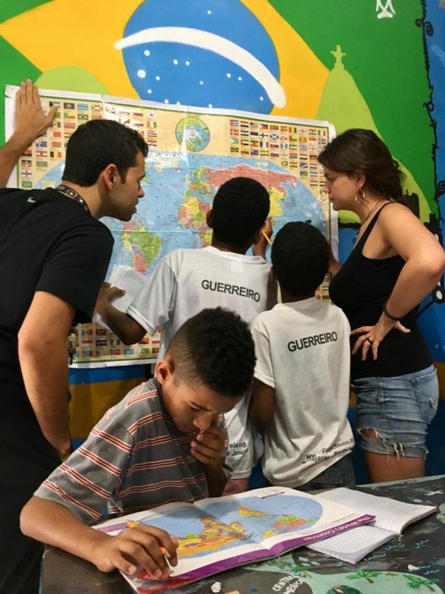 Crianças tendo aulas com mapas, dentro do project Favela, no Rio de Janeiro