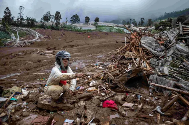 Warga mencari barang di antara puing rumahnya yang tertimbun material longsor di Desa Pasirlangu, Cisarua, Kabupaten Bandung Barat, Jawa Barat, Sabtu (24/1/2026). Berdasarkan data sementara BPBD Kabupaten Bandung Barat, sebanyak 30 rumah tertimbun material longsor serta 34 Kepala Keluarga (KK) atau 113 jiwa terdampak bencana tanah longsor yang terjadi pada Sabtu (24/1) dini hari. 